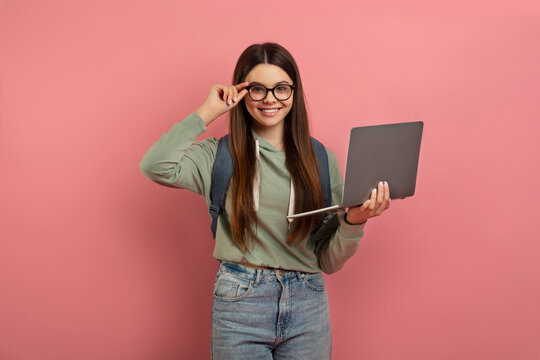 Portrait of smiling teen girl with laptop computer in hands