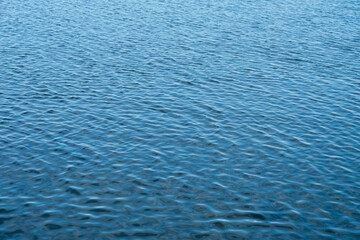 Obraz premium Blue seawater with ripples texture surface background, Island Ocean ocean waves flow with light refracting by the wind, Beautiful panoramic Nature banner