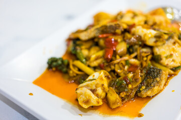 Stir fried spicy and delicious seafood on a white dish
