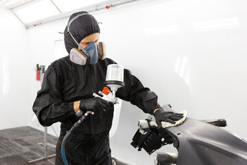 Preparation for painting a car element using emery sponge by a service technician leveling out before applying a primer after damage to a part of the body in an accident in the vehicle workshop - obrazy, fototapety, plakaty