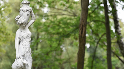 Kyiv, Ukraine, 03.08.2023. sculpture of a girl in the spring park. An old statue in a park of a...