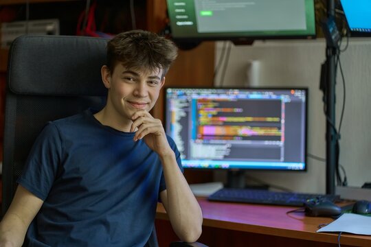 Young student learning computer science, coding, programming, IT classroom, system service administrator. Portrait of teenage boy.