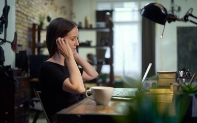 Businesswoman working with laptop computer in home office. Woman using the internet, searching, browsing, listening music online.
