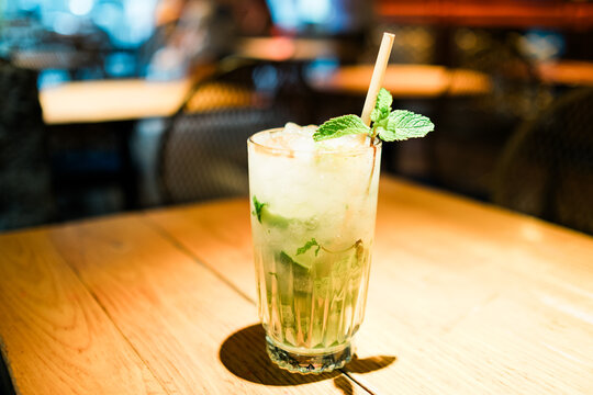 Mojito alcoholic cocktail with mint, lime slices and ice on a bar.Selective focus image