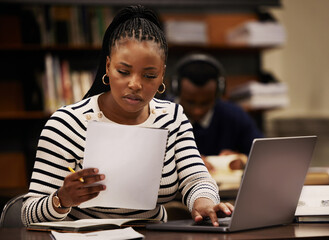 Student, woman and documents on laptop in library for study, research and planning in university....