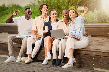 Diverse students taking selfie on smartphone at campus