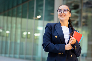 Happy smiling student young woman with books at university background