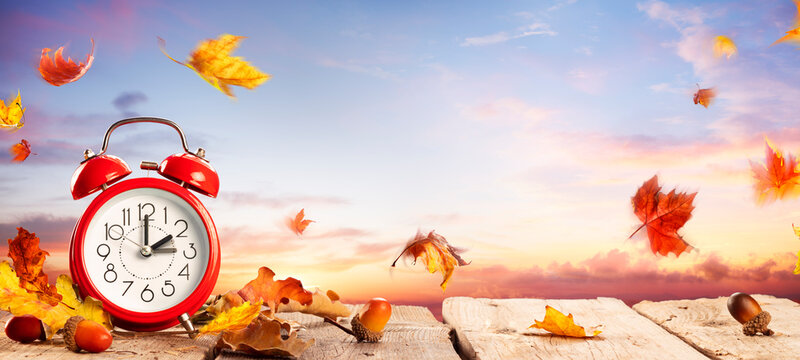 Fall Back Time - Daylight Savings End - Clock Alarm At Sunrise With Leaves - Return To Winter Time