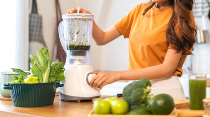 Fototapeta na wymiar Portrait of beauty healthy asian woman making green vegetables detox cleanse and green fruit smoothie with blender.young girl drinking glass of smoothie, fiber, chlorophyll in kitchen.Diet, healthy
