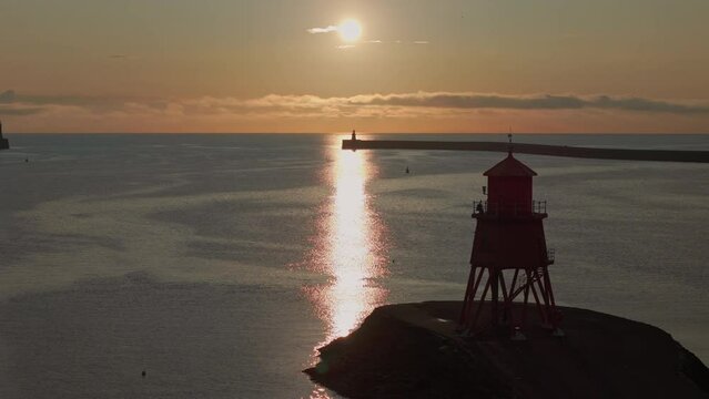Herd Groyne Lighthouse Panning Drone Shot with lighthouse crossing dawn Sun path 3x Zoom, Tynemouth, Tyne & Wear.