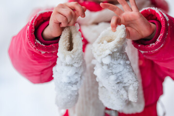 Frozen, icy baby mittens in the child's hands. Angina, cold, hypothermia.