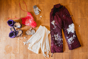 Dry wet snowy clothes on a warm floor in winter.