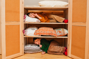 Children play hide and seek at home in winter.