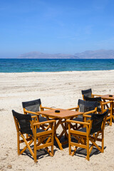 Fototapeta na wymiar Tables and chairs on the beach in the resort town of Mastichari on the island of Kos. Greece