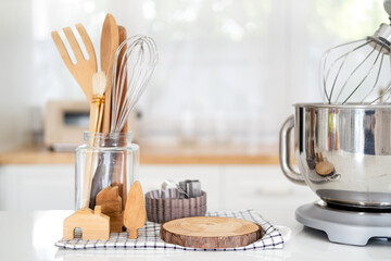 Kitchen utensils and wooden tools for homemade baking on a light kitchen background. Selective focus.