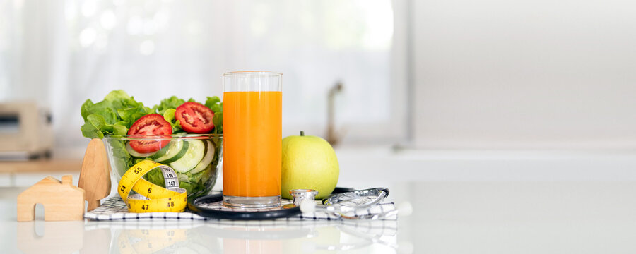 Plate of fresh vegetable salad, fruit juice milk and measuring tape stethoscope on light white table, banner with space for text. Healthy diet concept