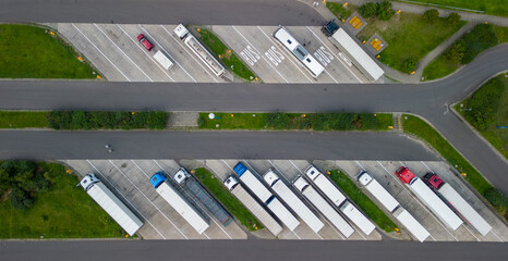 aerial drone view of parking with trucks and trailers near motorway