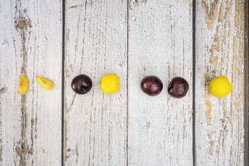 A row of ripe red and yellow plums