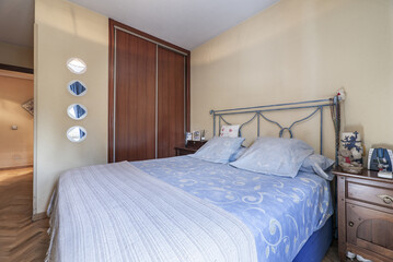 Fototapeta na wymiar Bedroom with double bed, built-in wardrobe with sliding doors