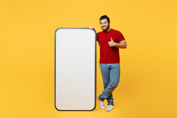 Full body young Indian man wearing red t-shirt casual clothes big huge blank screen mobile cell...
