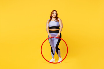 Full body smiling happy fun young chubby plus size big fat fit woman wear blue top warm up train hold hula hoop look camera isolated on plain yellow background studio home gym. Workout sport concept. - Powered by Adobe