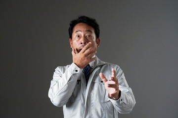 驚くミドルエイジの作業員　黒背景