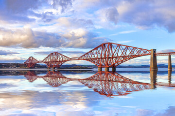 The Forth Rail Bridge, one of Scotland's most famous landmarks, with a reflection in the Firth of Forth. Designed by engineers Sir John Fowler and Sir Benjamin Baker. Reflection has been added.