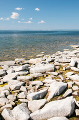 Uvildy lake in summer with stones on its shore in the foreground, South Urals, Russia