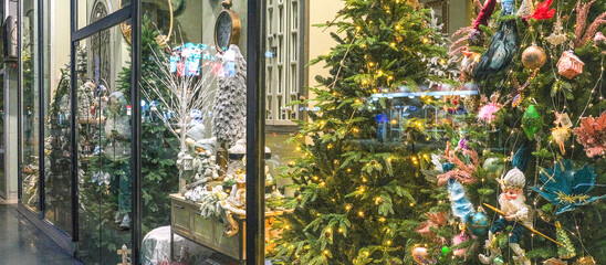 Christmas shop window decorated with christmas gift Beautiful festive Christmas storefront with decorated artificial Christmas trees and toys