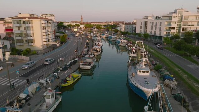 Aerial shot of a Caorle, the Resort sea beach city near to Venice. Fisherman boats in lagoon at sunset time