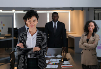 Portrait of a confident businesswoman with an ethnic business team in the background