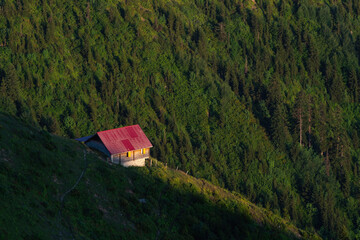 Highland house at sunset on a forested mountain slope in a low valley in the Black Sea region of Turkey