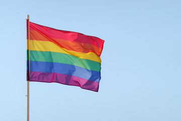 Pride flag. Rainbow flag, LGBT flag in front of blue sky. Pride month. Copy space.