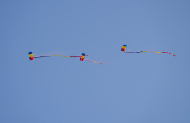Flag of Romania concept image. Paratroopers with the Romanian flag in flight against clean blue sky.