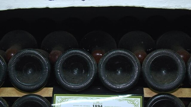 Old Aged Wine Bottles Storage in Dark Rustic Cellar Basement, Stack of Lying Dir