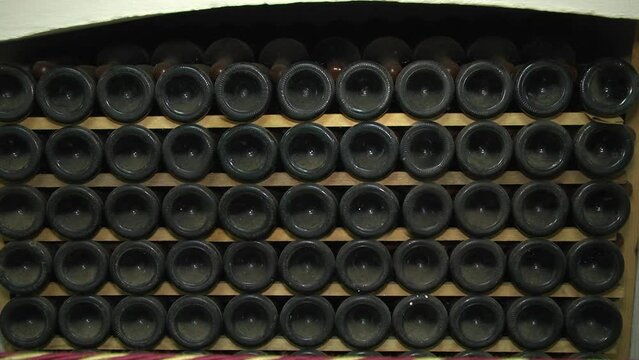 Old Aged Wine Bottles Storage in Dark Rustic Cellar Basement, Stack of Lying Dir