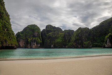 Beautiful and empty beach. Sea and high rocks. The famous Maya Bai. Sunny morning. Colorful sea.