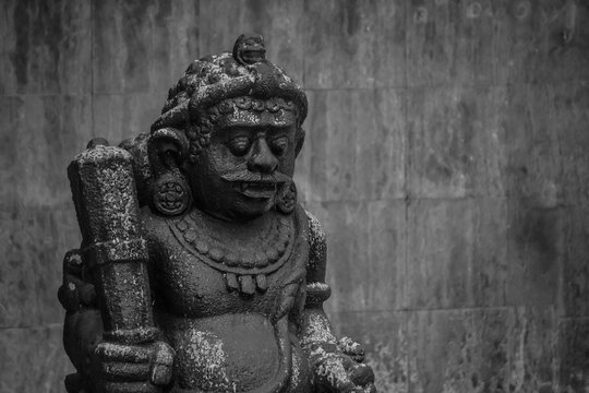 Dwarapala is traditional Javanese guardian statues holding a large mace in the form of gods, people or demons. Indonesian sculpture made of stone carvings in temple or shrine sacred place gate.
