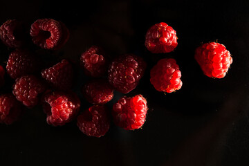 ripe red raspberries on a dark background