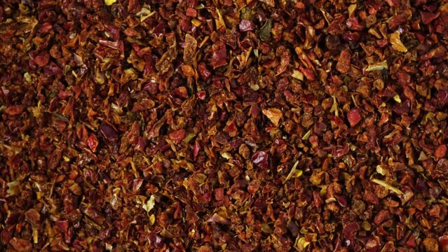 Dried crushed pepper Gochugaru, close-up. Medium-ground red dry pepper uses in Korean cuisine for kimchi, gochujang and other savory dishes. Popular spicy condiments. 4K video, Rotating.