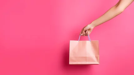Fotobehang Hand holding colorful shopping bag on blank background with copy space  © kimly