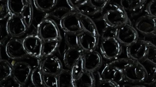 Black Pretzels with sea salt, close-up. 4K Video, Rotating. Baked bagels, baranki. Popular snack for beer. Trendy fast food on Oktoberfest.