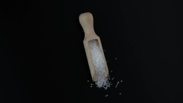 Monosodium glutamate, MSG powder in wooden scoop. 4K video, Rotating. Chinese salt, food additive E621 used in food industry. Oblong white crystalline granules. Fifth taste, umami.