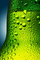 green bottle with beer in drops close-up