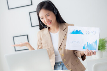 Young asian business woman using laptop computer for video conference online, businesswoman working with video call for meeting and showing graph report for finance, communication concept.