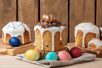 Delicious Easter cake with icing, chocolate nest and painted eggs on wooden table. Side view.