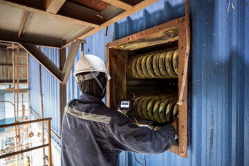 Male worker inspection measured the open window bent coil pipe circular thickness of the boiler and...