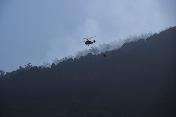 Wildfire Suppression: Helicopter in Action Against Blaze