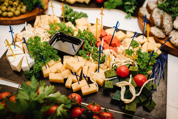 Food on wooden plates, serving board on festive table, corporate food. Buffet table. Mini cold...