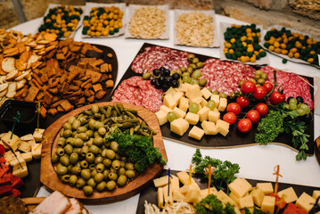 Food on wooden plates, serving board on festive table, corporate food. Buffet table. Mini cold snacks, appetizers for public catering. Party and holiday away. Decorating an event in hall restaurant.